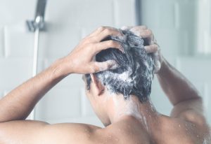 Man showering and shampooing his hair for Hair Care for Men Downers Grove.