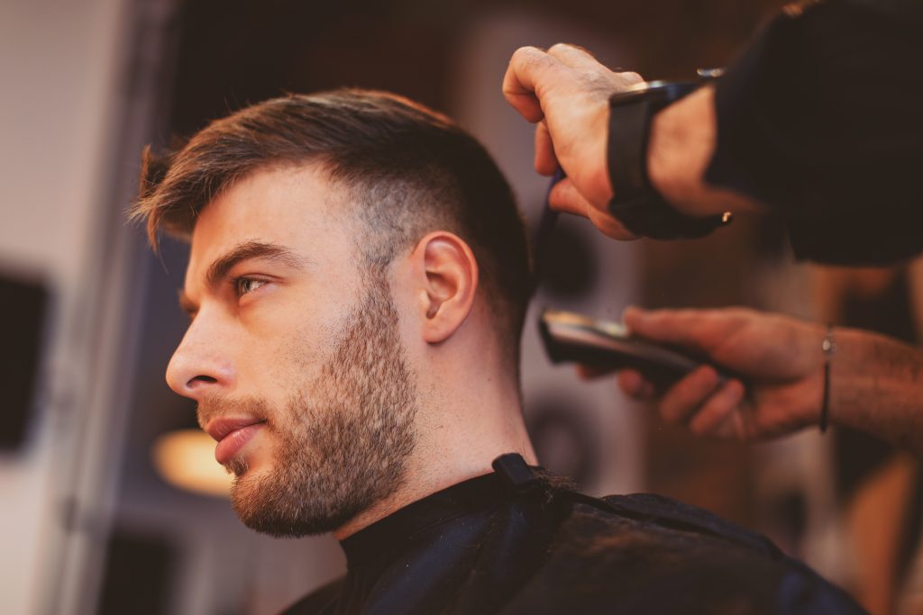 2026 Men's Hairstyle Trends A man with a beard receives a haircut at a barber shop, from men's stylist in Orland Park.